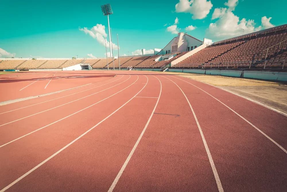 Empty running track with stadium seating in background Empty running track with stadium seating in background