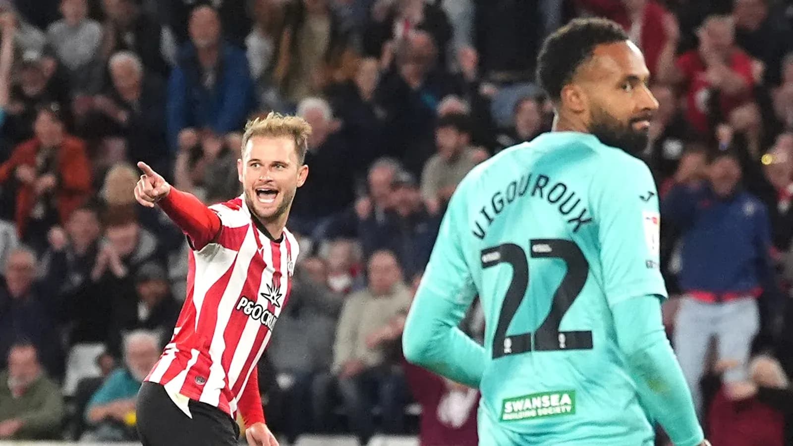 Player celebrating a goal against Swansea City goalkeeper Player celebrating a goal against Swansea City goalkeeper