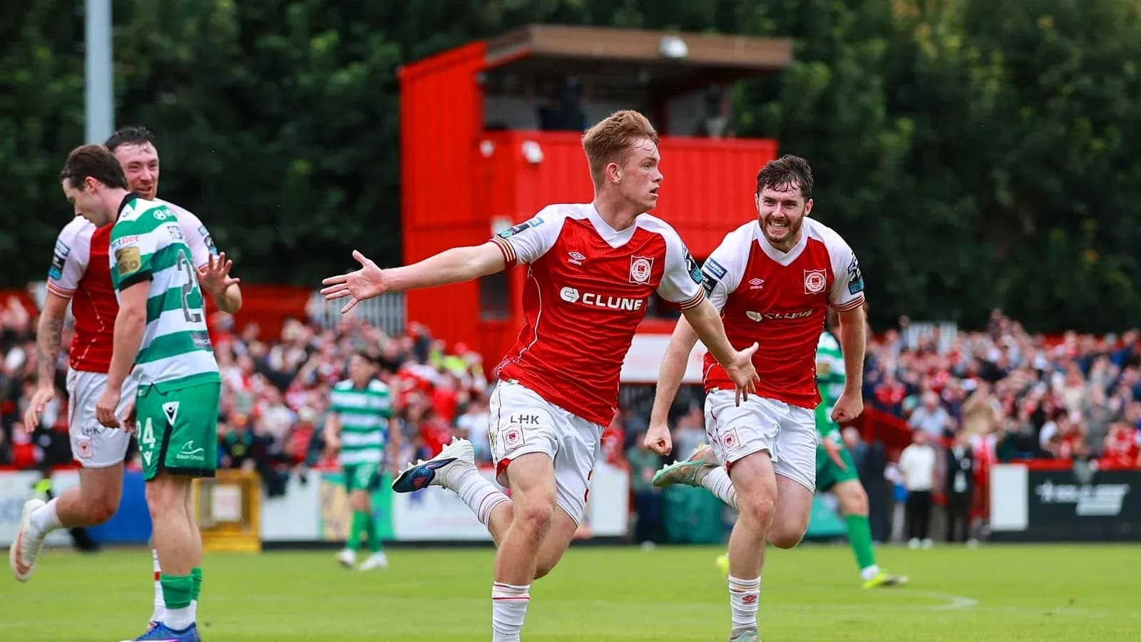 Player celebrating a goal with teammates on pitch Player celebrating a goal with teammates on pitch
