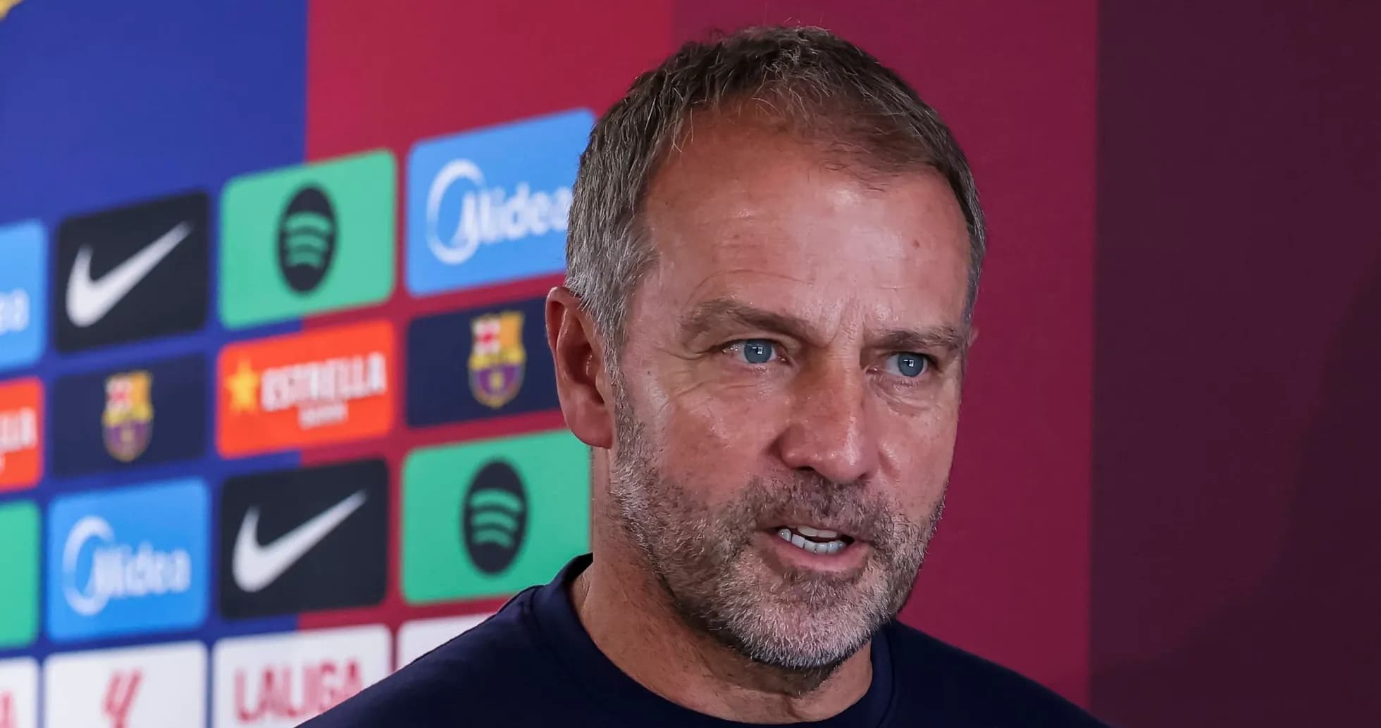Manager speaking at press conference with logos behind Manager speaking at press conference with logos behind