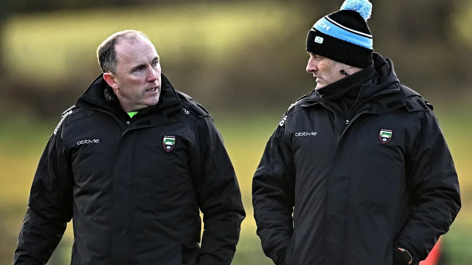 Two coaches discussing during training session outdoors Two coaches discussing during training session outdoors