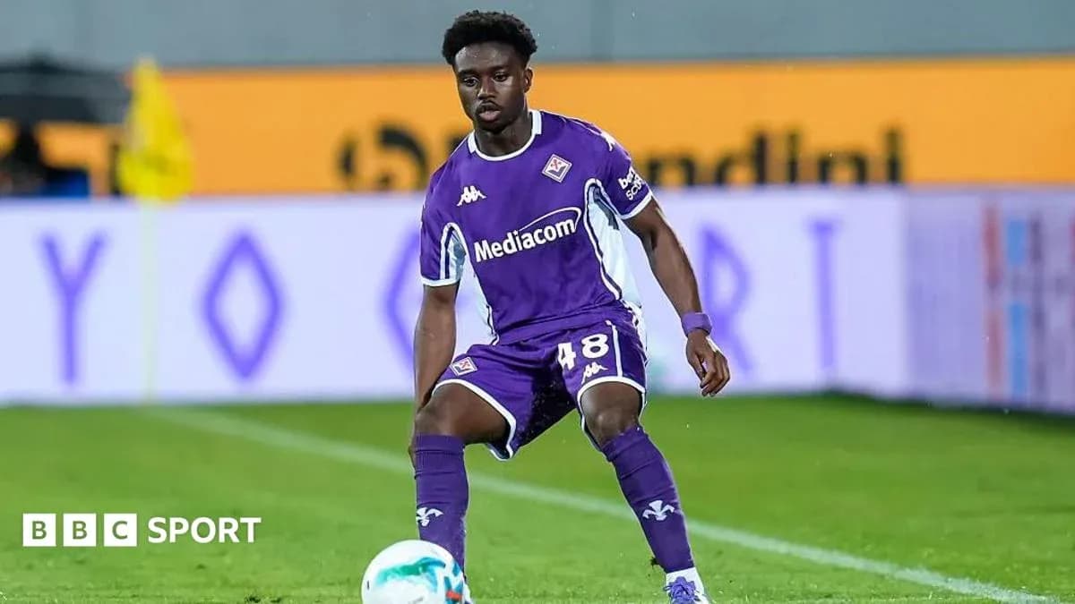 Player in purple kit preparing to pass ball Player in purple kit preparing to pass ball