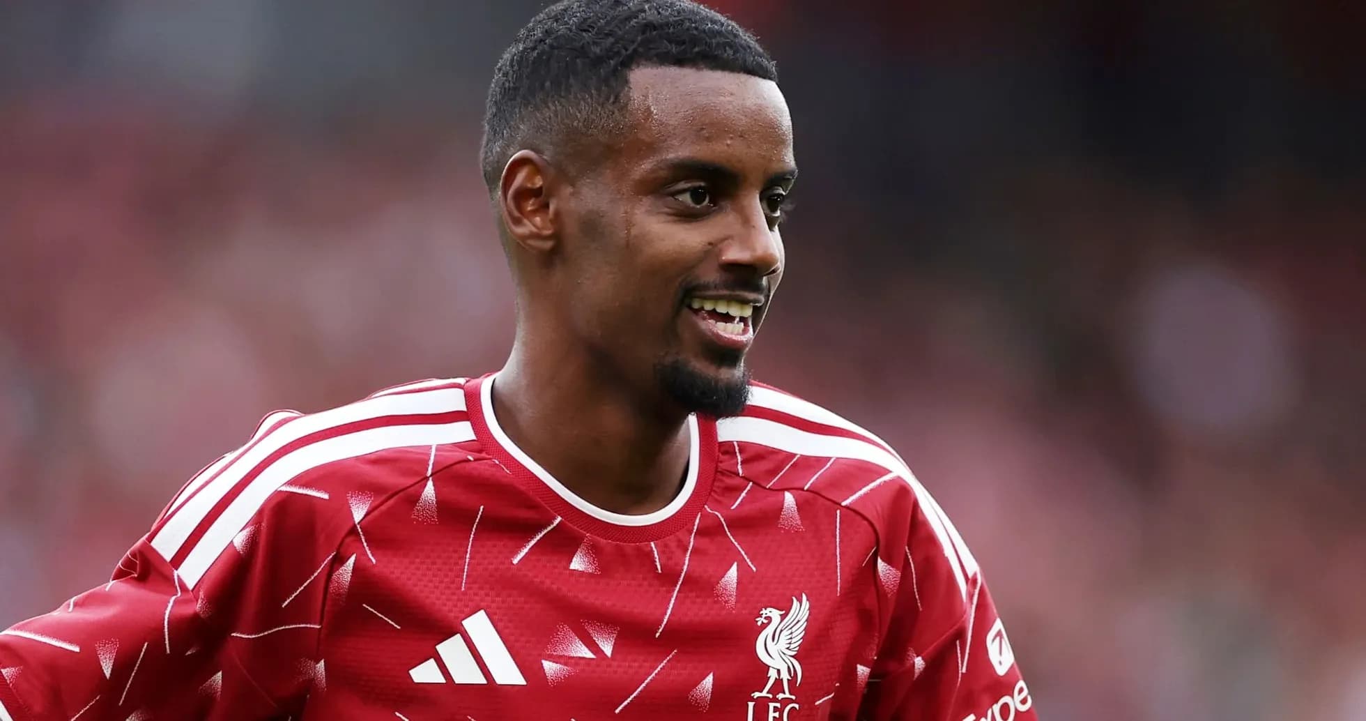 Player smiling in Liverpool training kit Player smiling in Liverpool training kit