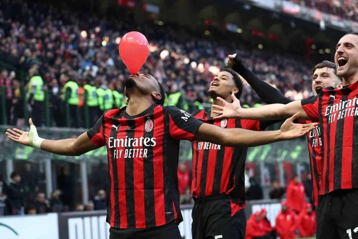 AC Milan players celebrating with a balloon on pitch AC Milan players celebrating with a balloon on pitch