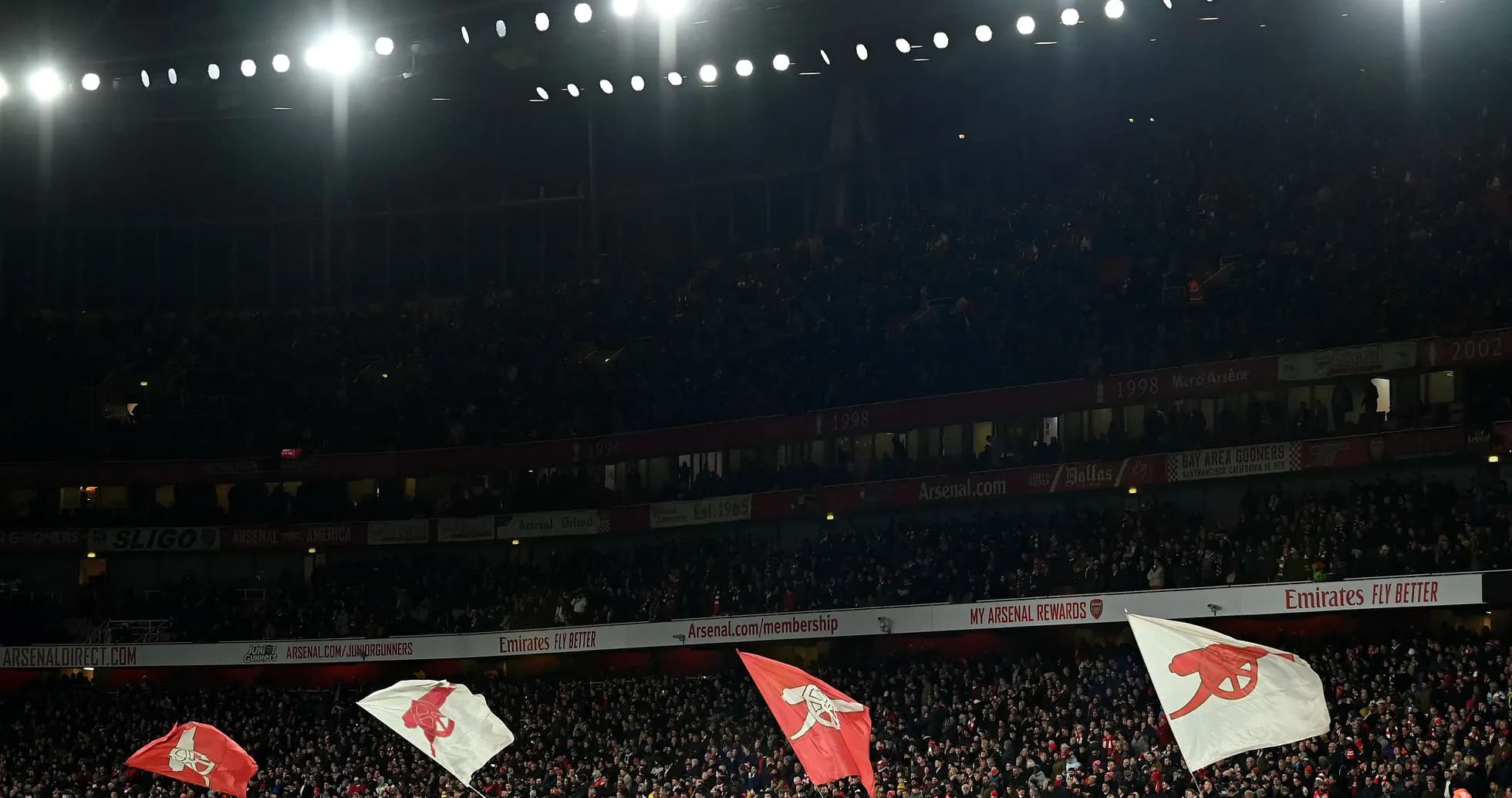 Fans waving Arsenal flags in crowded stadium Fans waving Arsenal flags in crowded stadium