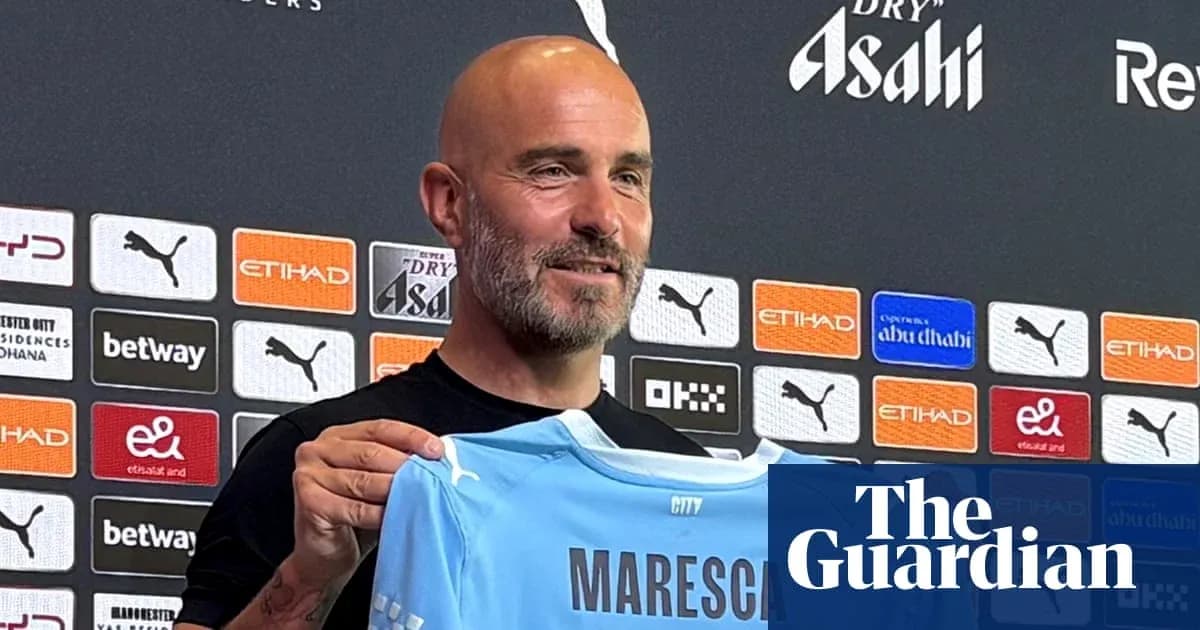 Manager holding Manchester City jersey at press conference Manager holding Manchester City jersey at press conference