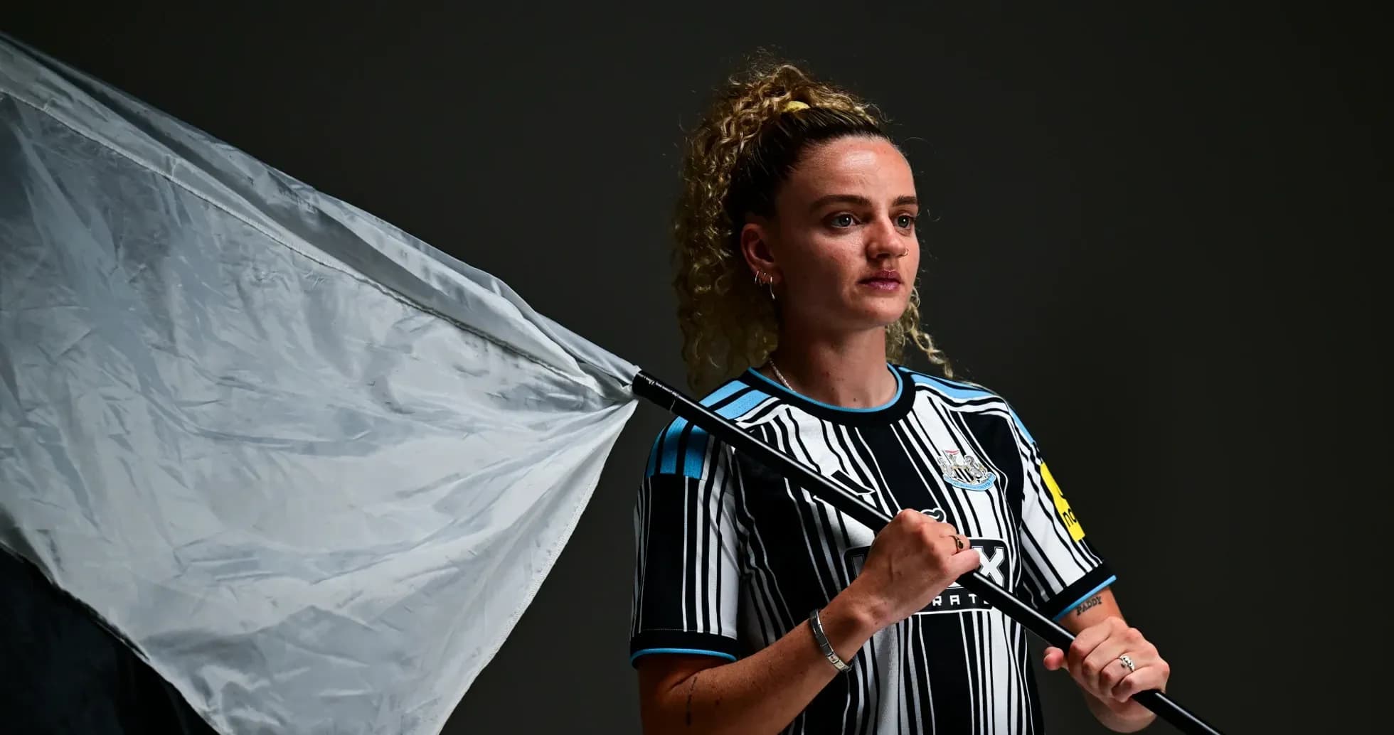 Player holding a flag wearing Newcastle jersey Player holding a flag wearing Newcastle jersey