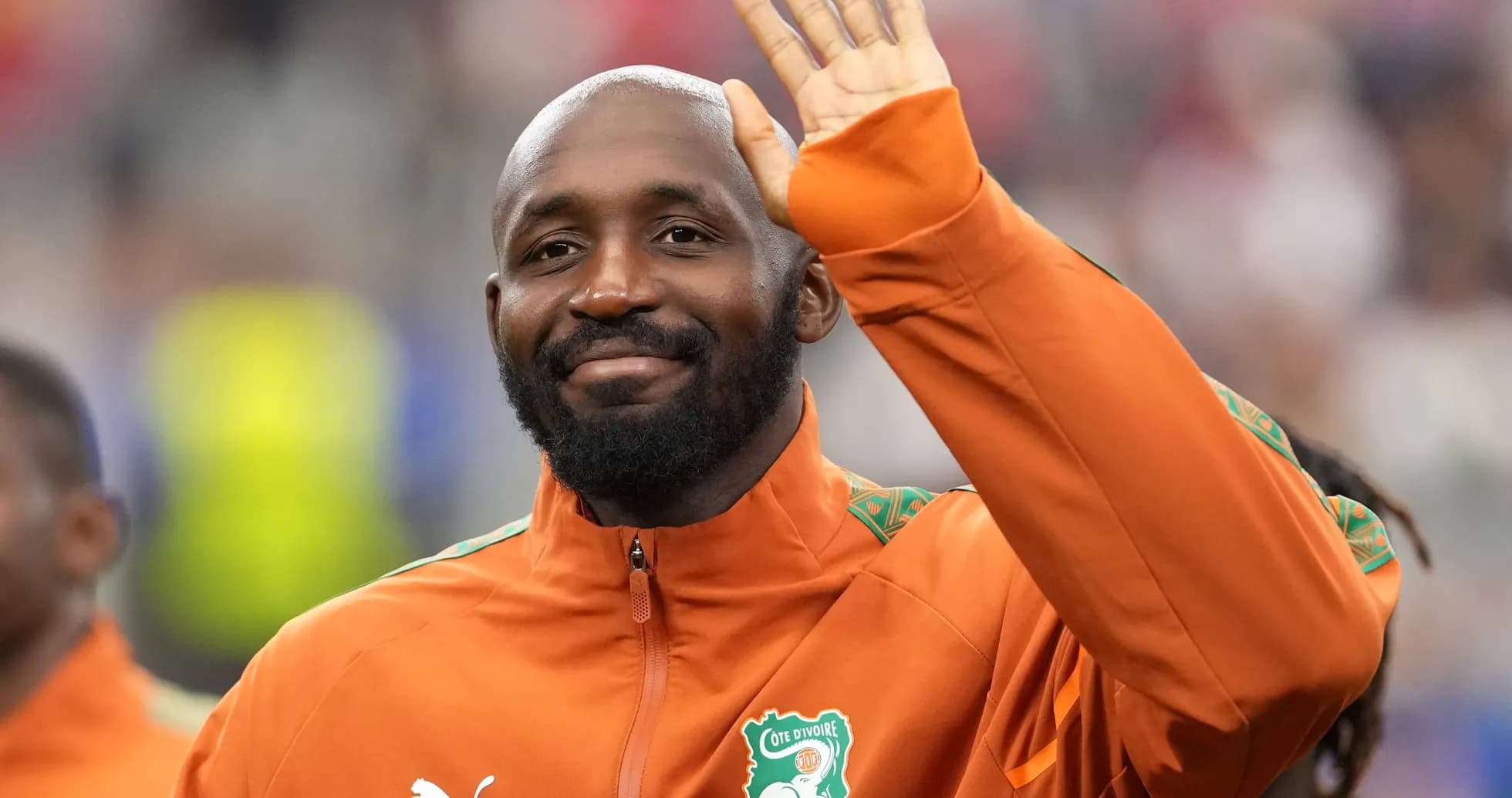 Player waving while wearing Côte d'Ivoire team jacket Player waving while wearing Côte d'Ivoire team jacket