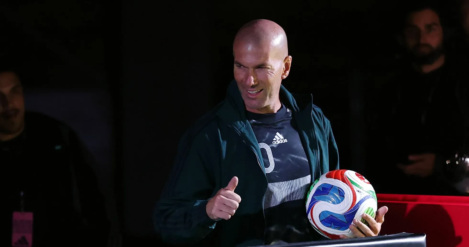 Zinedine Zidane holding a soccer ball and smiling Zinedine Zidane holding a soccer ball and smiling