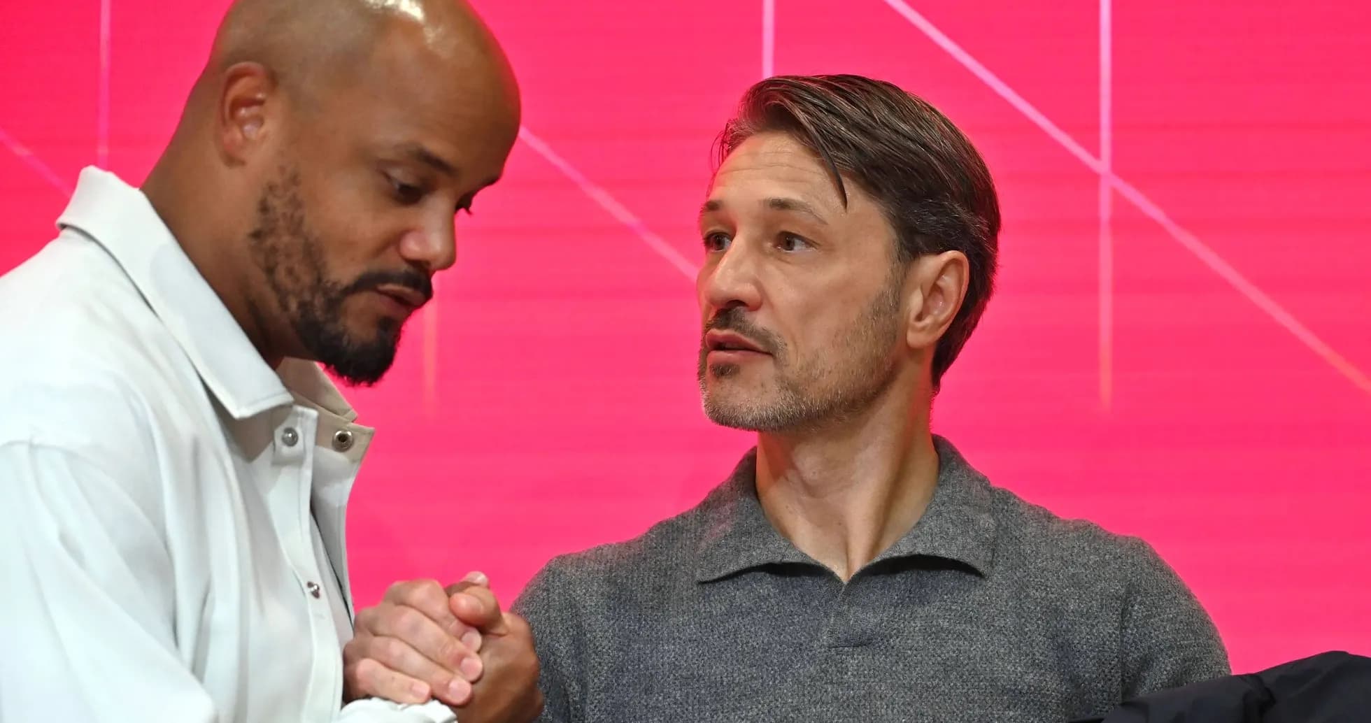 Two men shaking hands during a press event Two men shaking hands during a press event