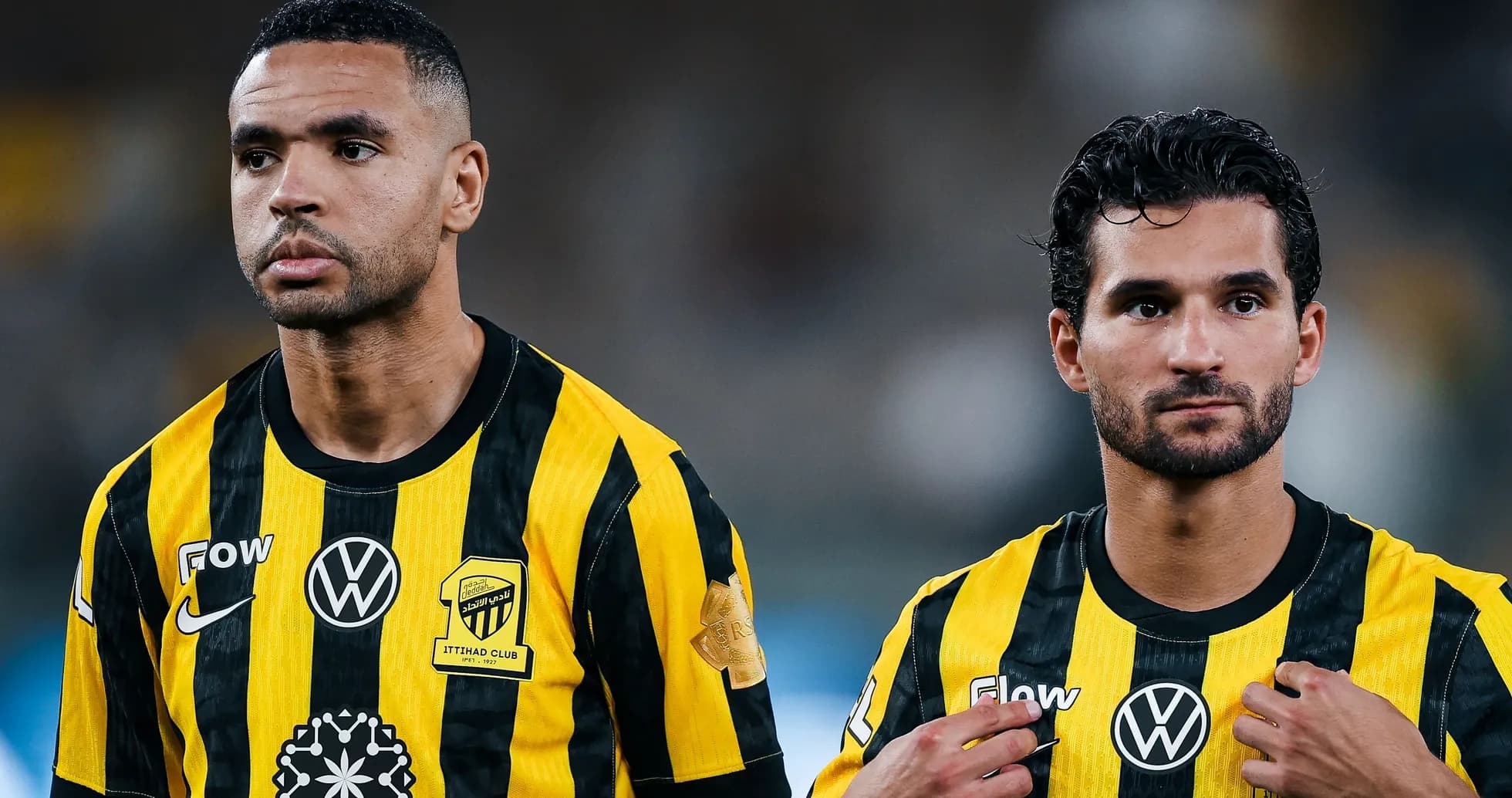 Two players in Ittihad Club jerseys on field Two players in Ittihad Club jerseys on field