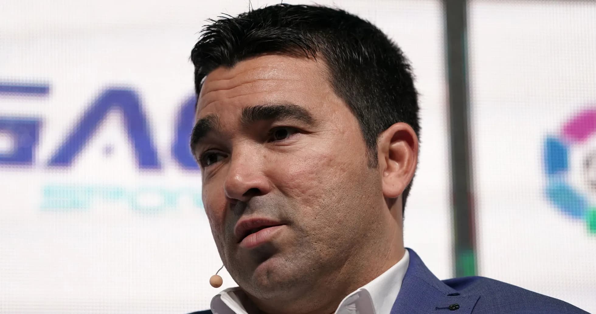 Man speaking at event with microphone attached Man speaking at event with microphone attached