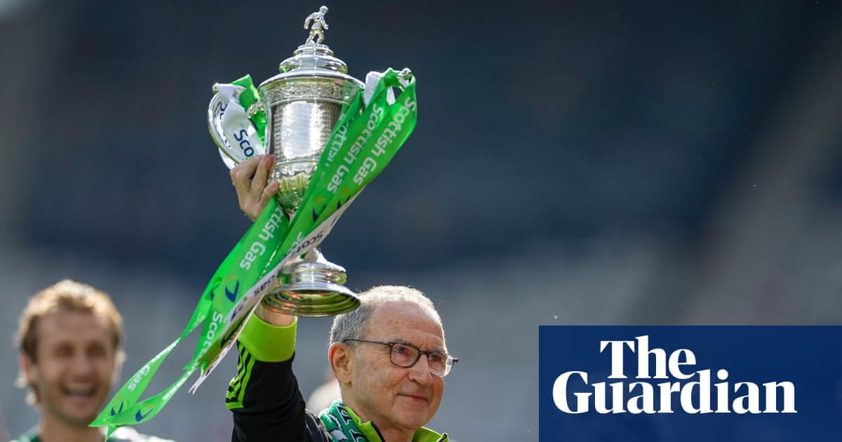 Coach holding trophy with green ribbons aloft Coach holding trophy with green ribbons aloft