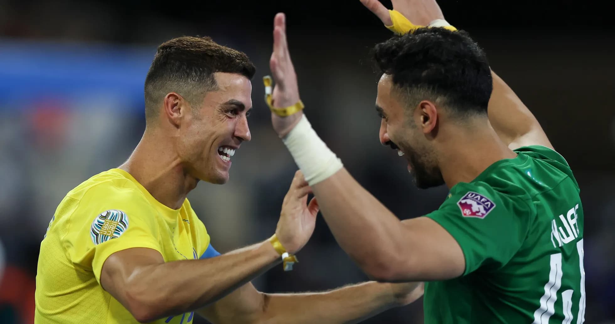 Two players celebrating a goal on the field Two players celebrating a goal on the field