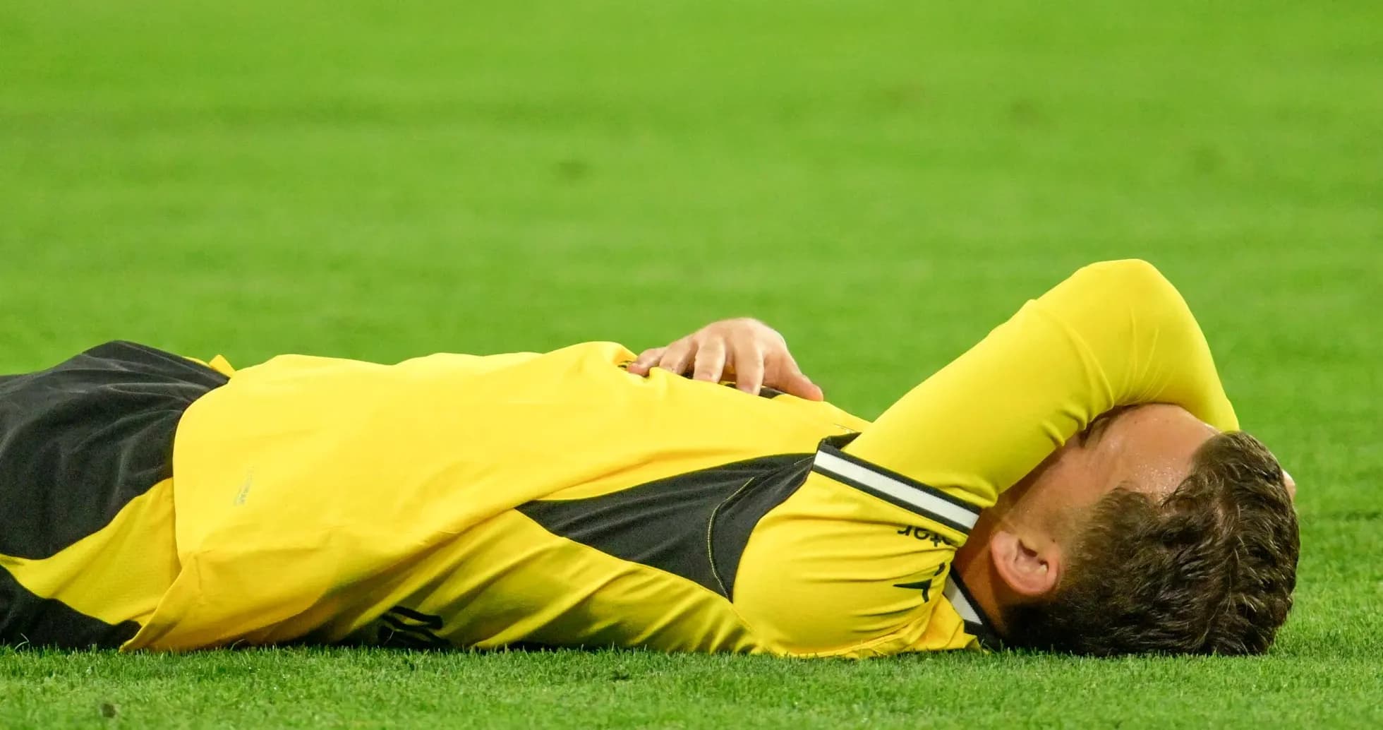 Player lying on the field after a play Player lying on the field after a play