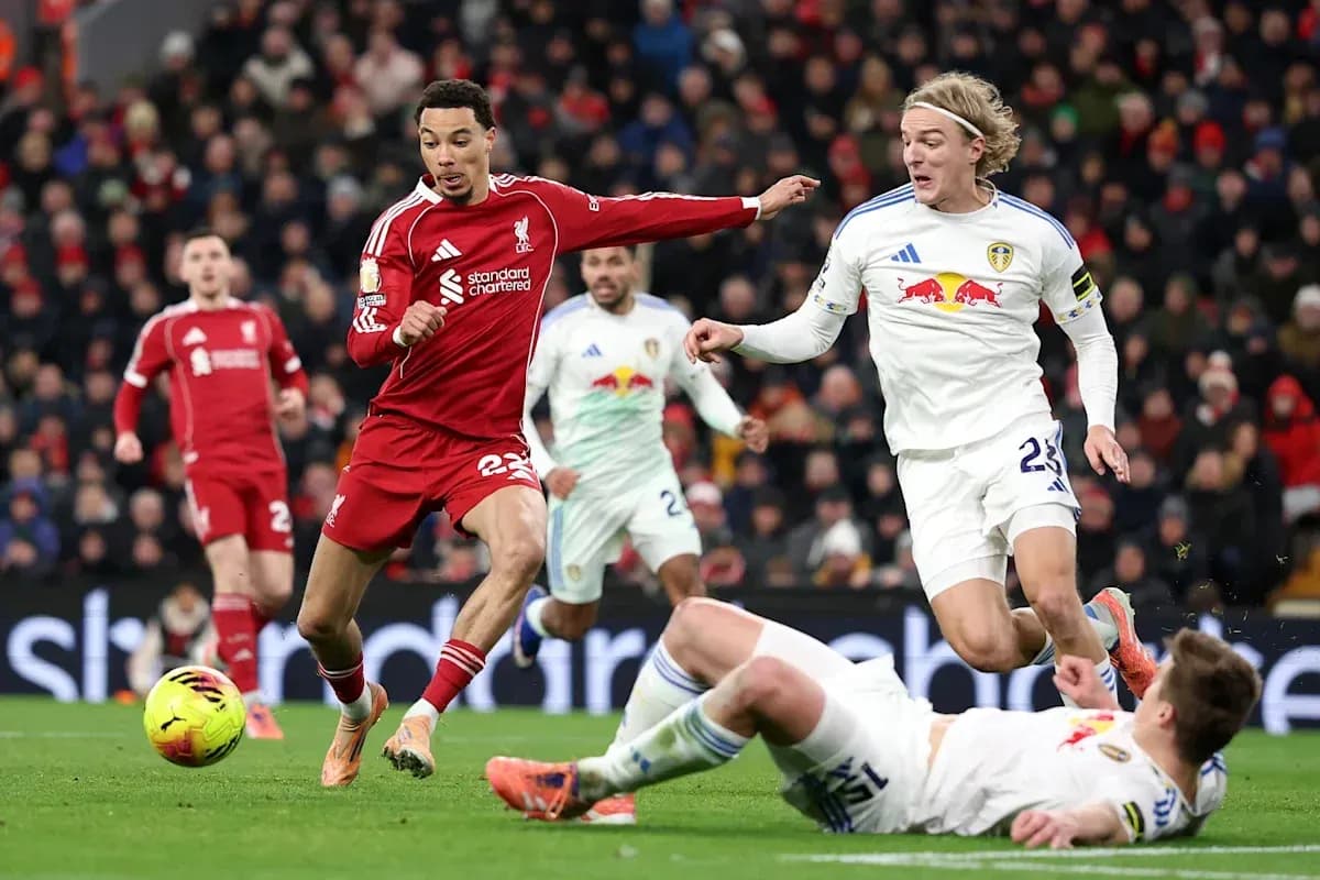 Liverpool player dribbling past Leeds defenders during match Liverpool player dribbling past Leeds defenders during match