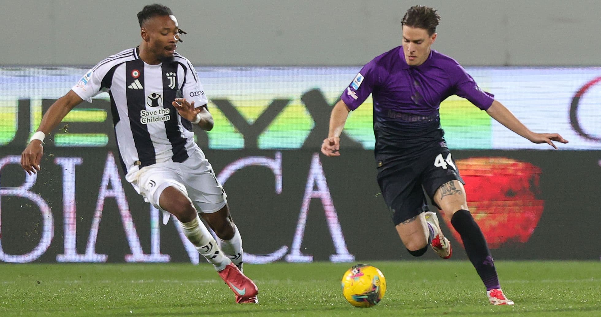 Juventus player challenging Fiorentina opponent for ball Juventus player challenging Fiorentina opponent for ball