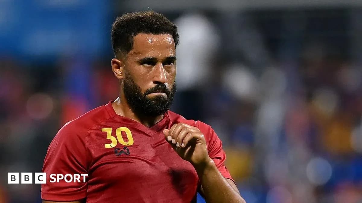Player in red jersey during match with focused expression Player in red jersey during match with focused expression