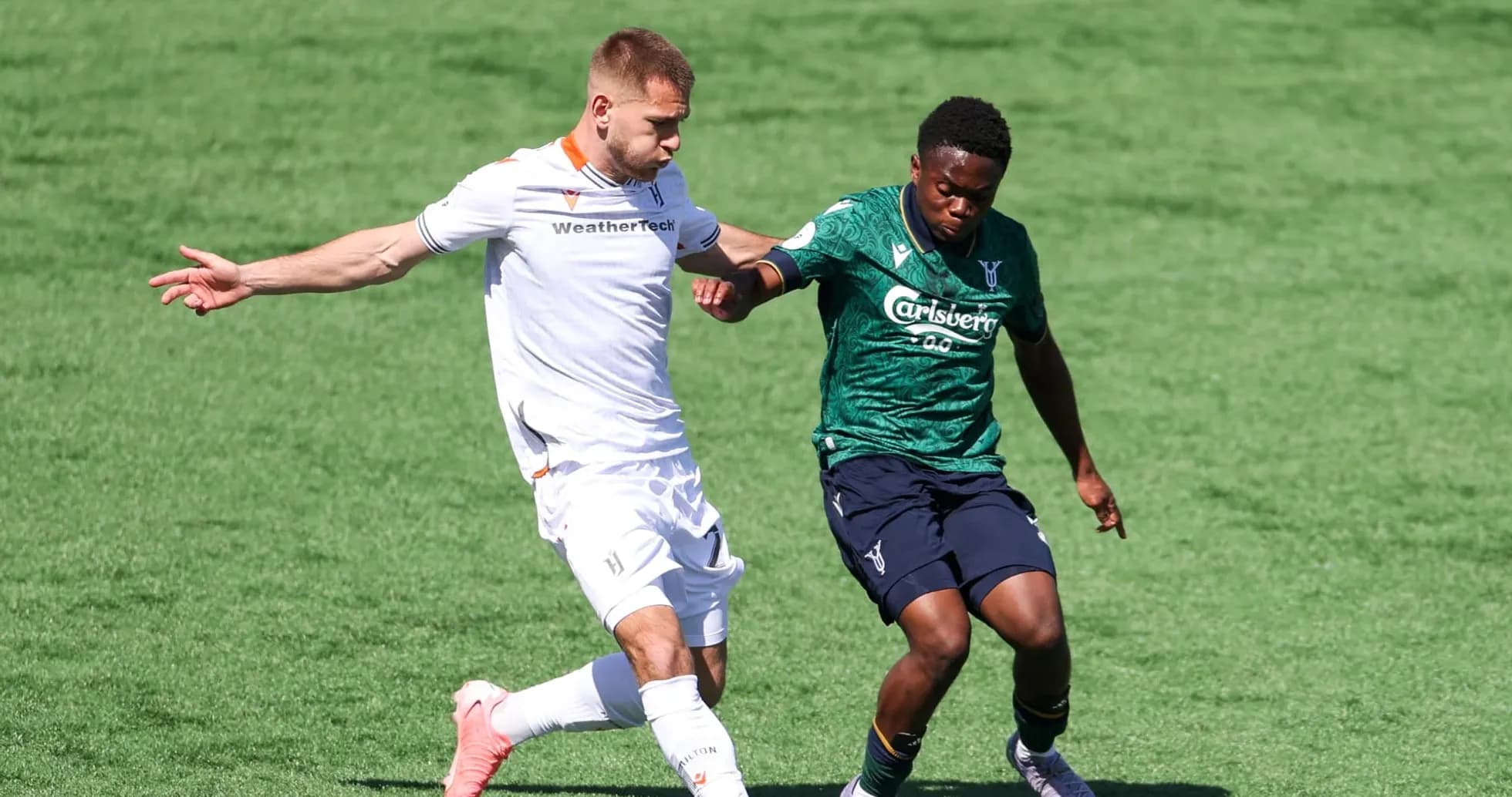 Two players competing for the ball in football match Two players competing for the ball in football match