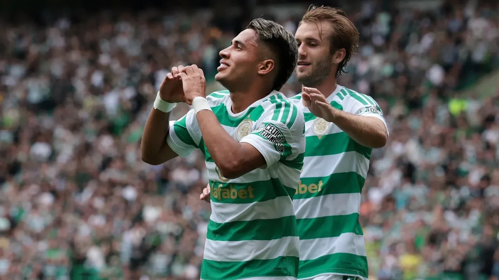Celtic players celebrating a goal on the pitch Celtic players celebrating a goal on the pitch
