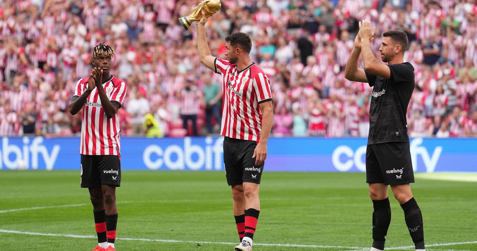 Players celebrating with a trophy in stadium Players celebrating with a trophy in stadium