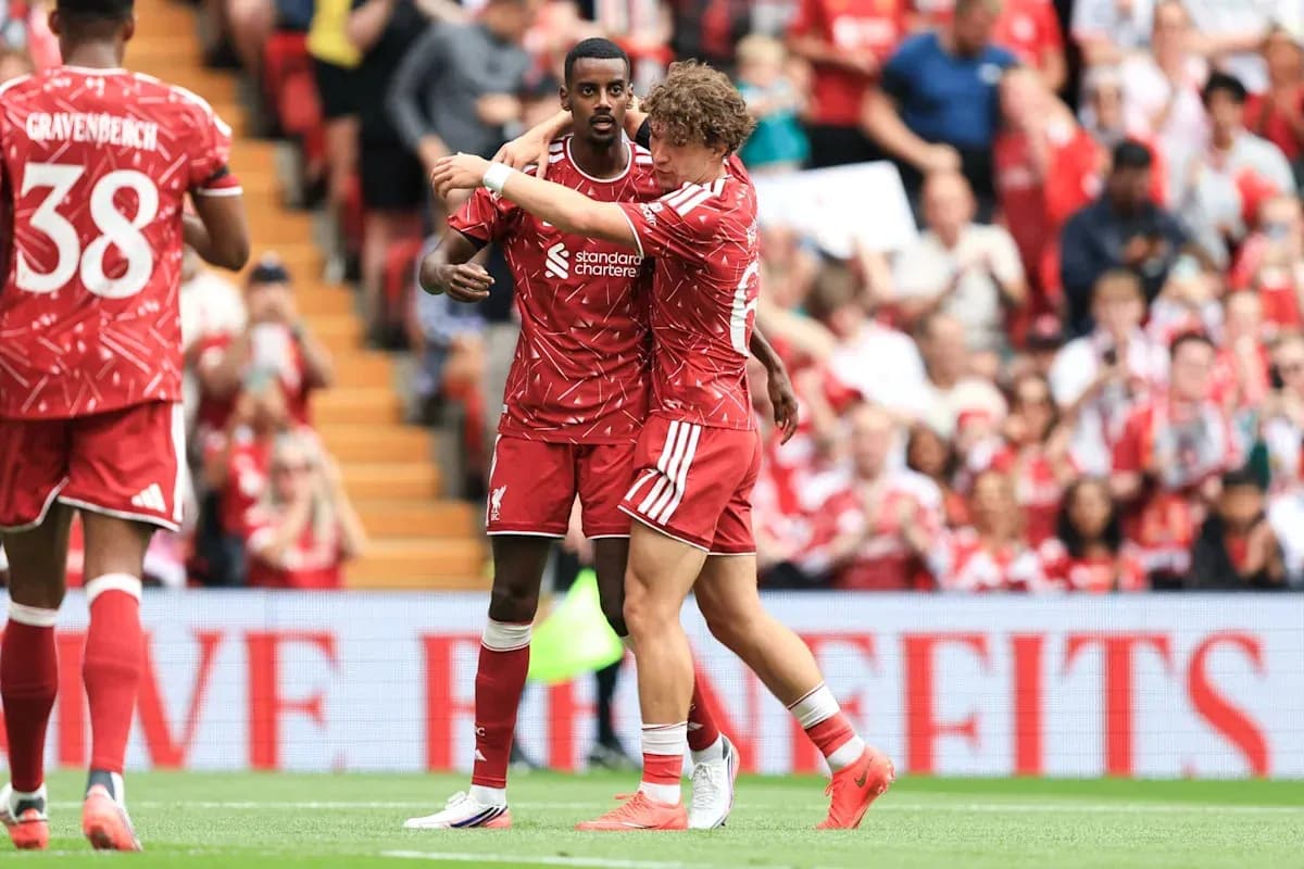 Two Liverpool players celebrating a goal on field Two Liverpool players celebrating a goal on field