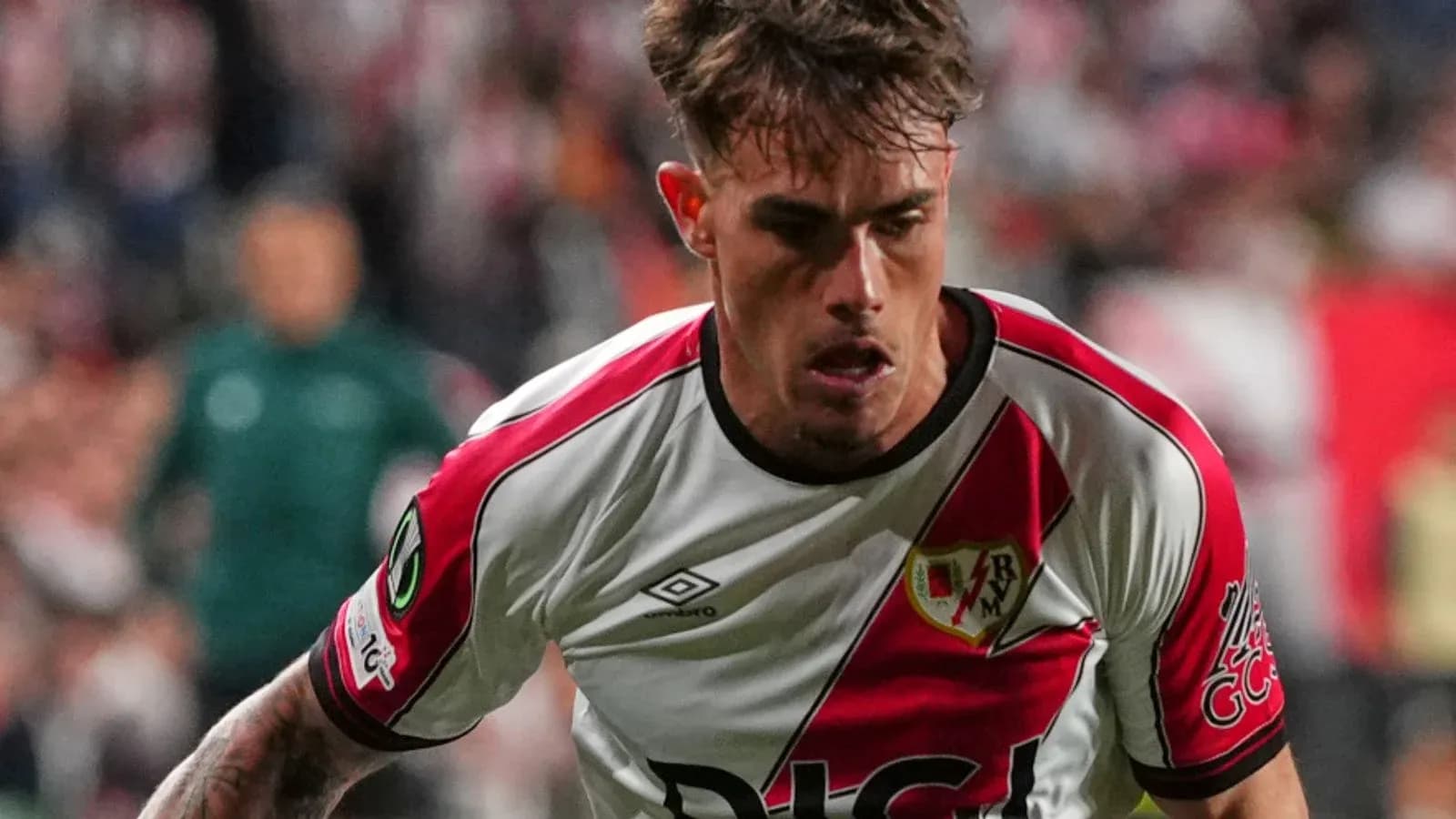Player in Rayo Vallecano jersey running during match Player in Rayo Vallecano jersey running during match
