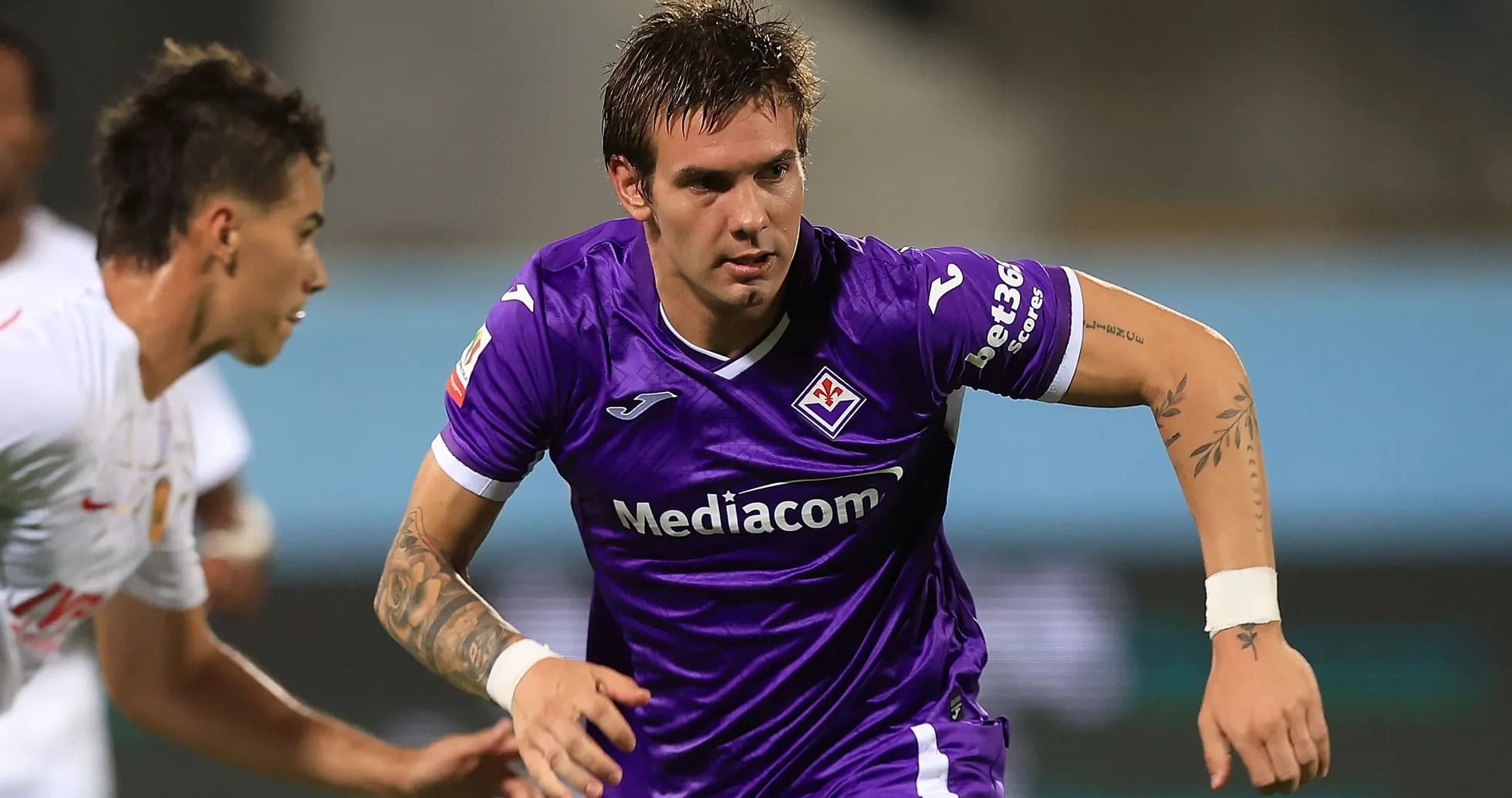 Player in purple jersey dribbling the ball during match Player in purple jersey dribbling the ball during match
