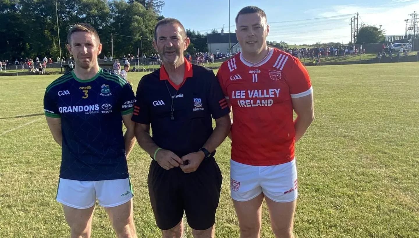 Two players and a referee posing on field Two players and a referee posing on field