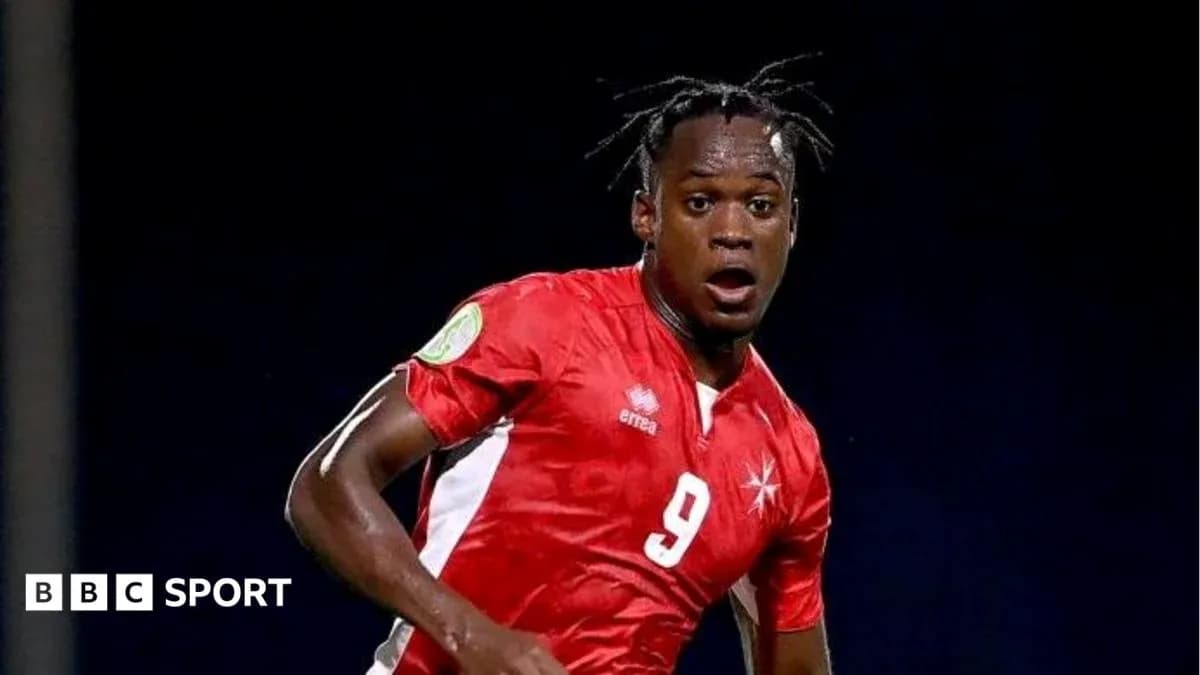 Player in red jersey running during a match Player in red jersey running during a match