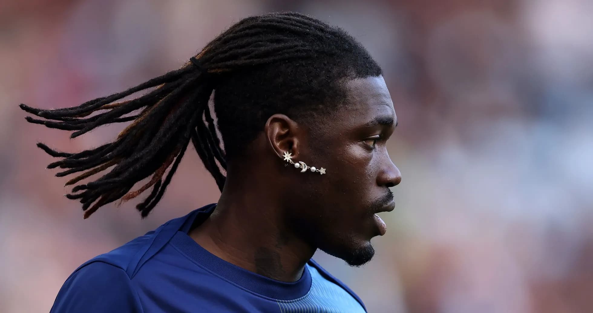 Player with dreadlocks and unique earrings on field Player with dreadlocks and unique earrings on field