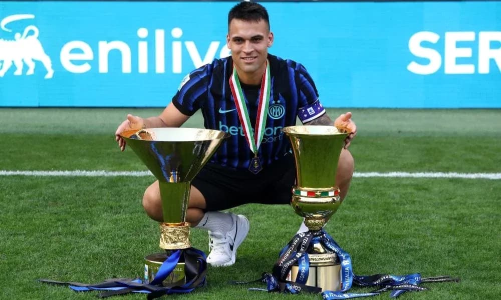 Player posing with two trophies on the field Player posing with two trophies on the field