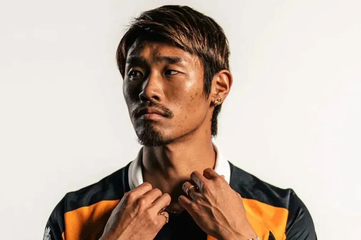 Athlete posing in sports jersey against plain background Athlete posing in sports jersey against plain background