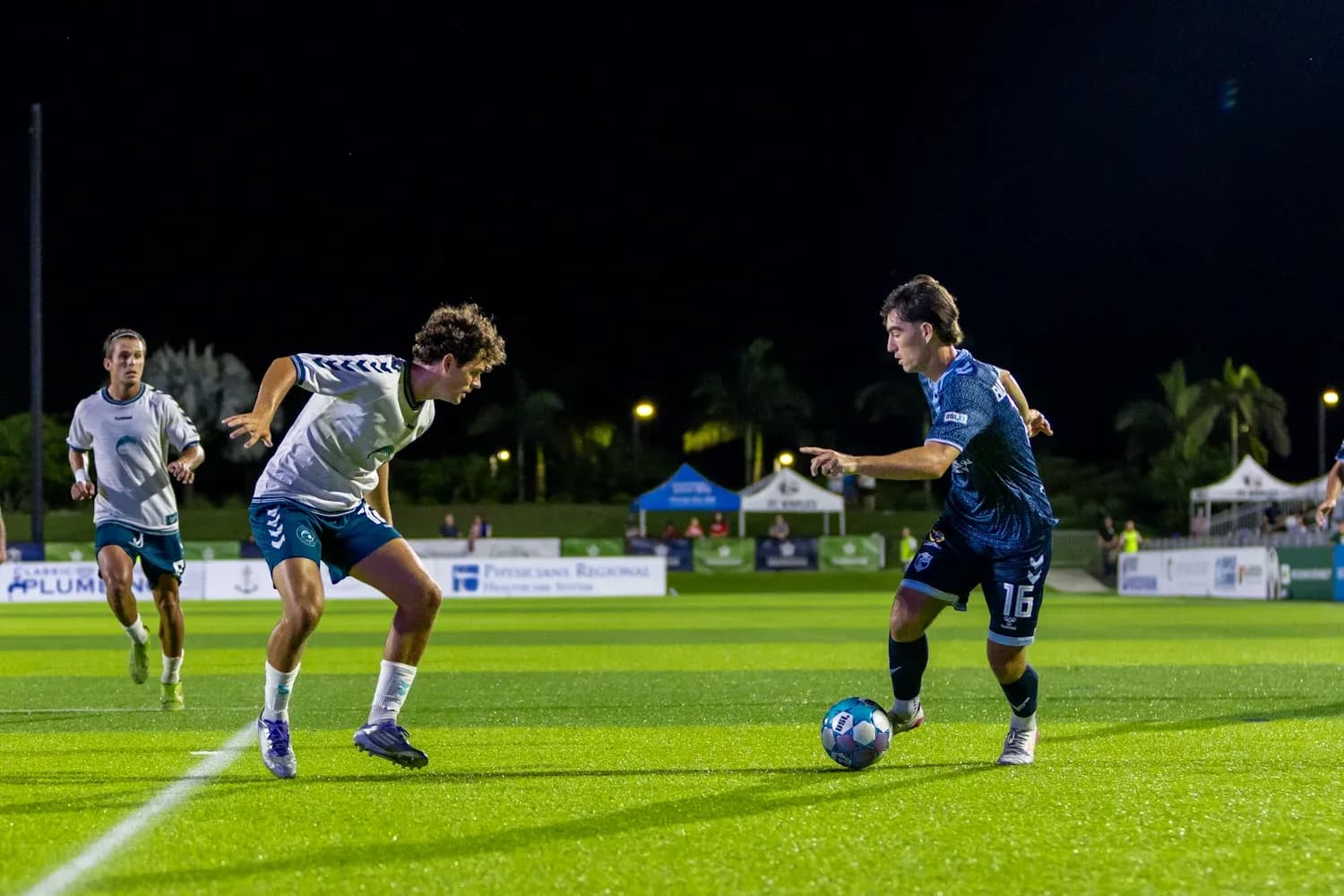 Two players competing for the ball in football match Two players competing for the ball in football match