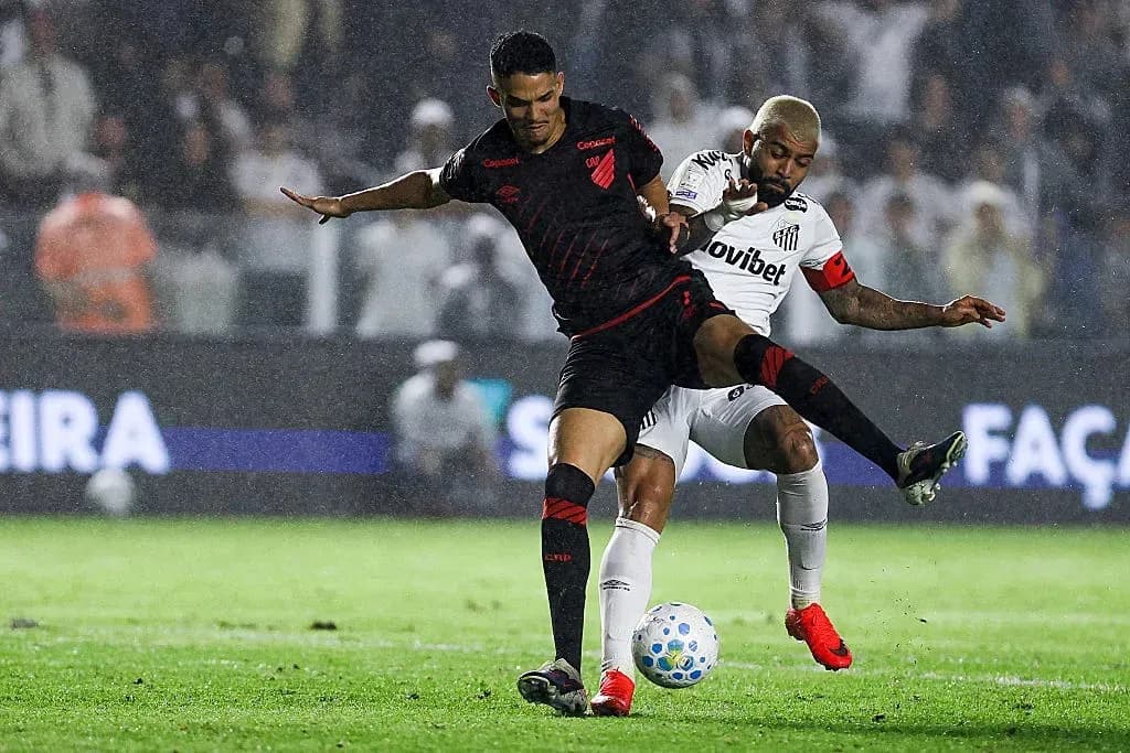 Players battling for possession during a rainy match Players battling for possession during a rainy match