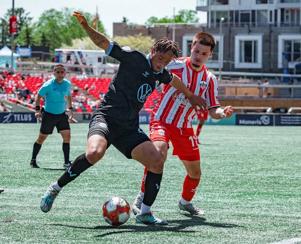 HFX Wanderers FC player tackling Atlético Ottawa player HFX Wanderers FC player tackling Atlético Ottawa player