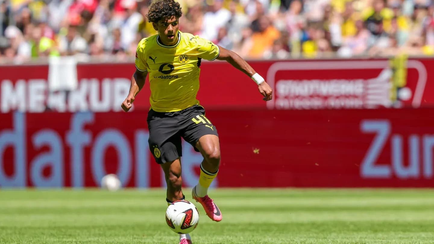 Player in yellow jersey dribbling ball on field Player in yellow jersey dribbling ball on field