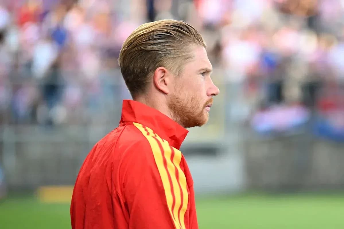 Player in red jacket during warm-up on field Player in red jacket during warm-up on field