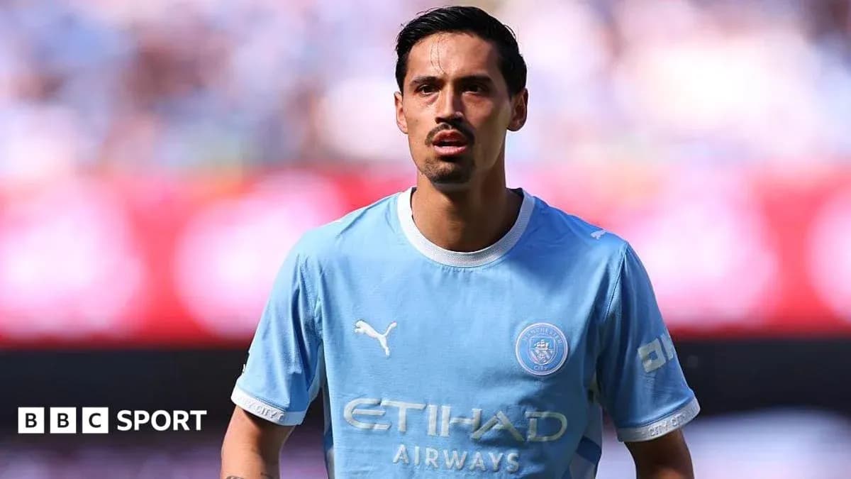 Player in light blue Manchester City jersey on field Player in light blue Manchester City jersey on field
